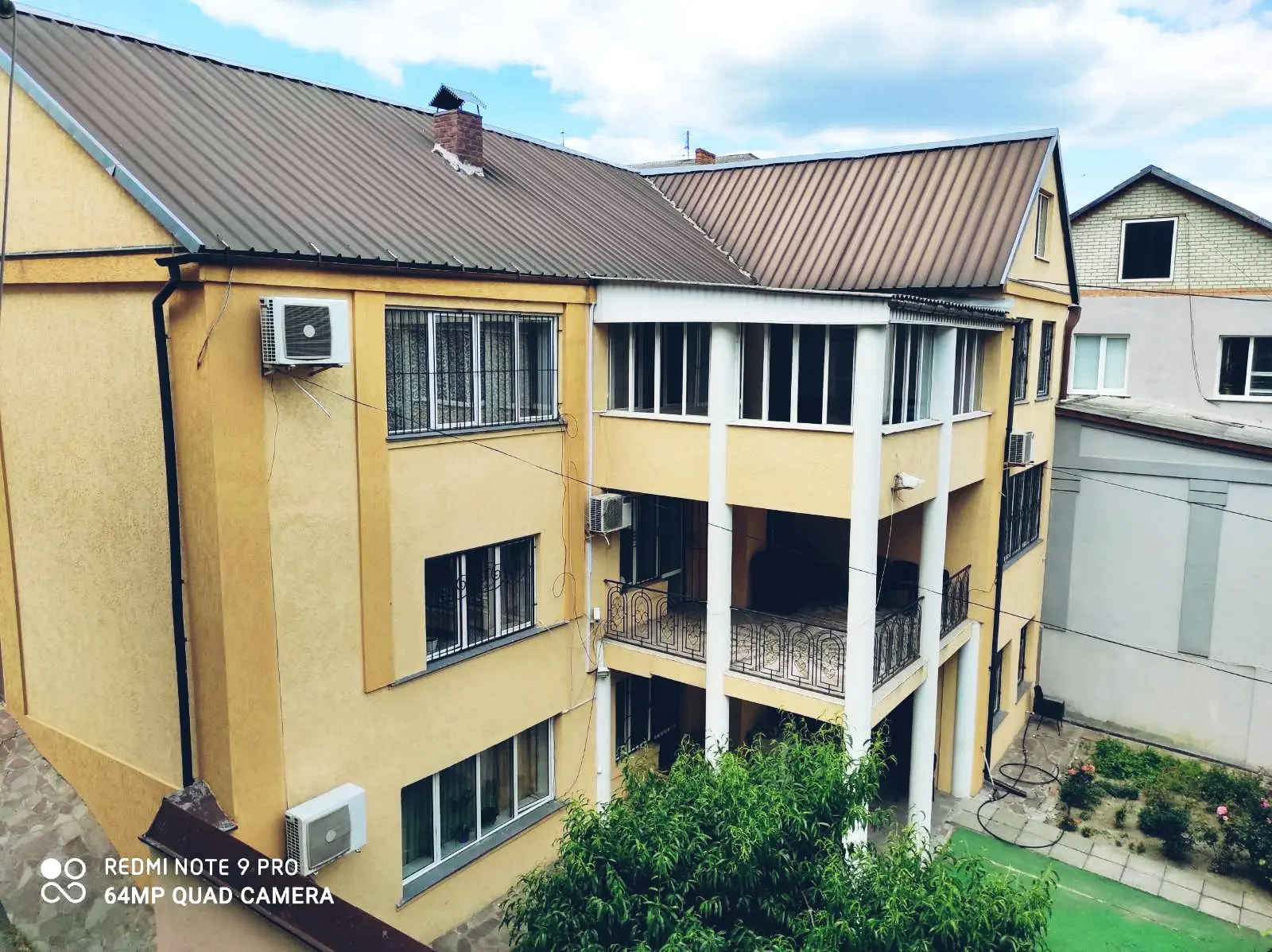 Зелёный двор и фасад пансионата с колоннами